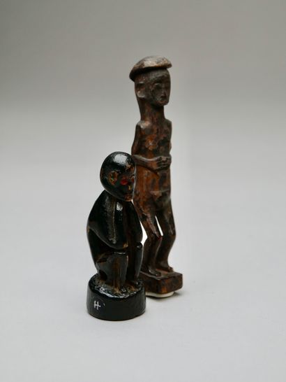 A seated figure and a standing figure with...
