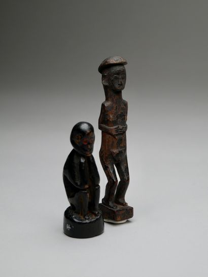A seated figure and a standing figure with...