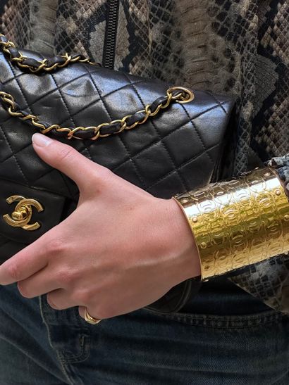 CHANEL
Grande manchette en métal doré surmonté...