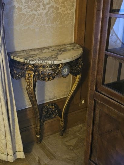 Gilded wooden console table resting on two...