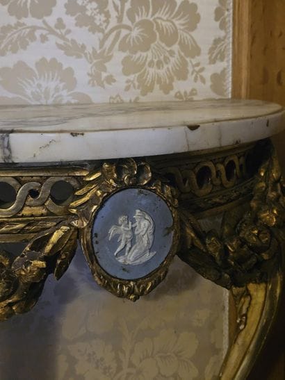 Gilded wooden console table resting on two...