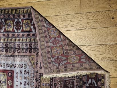 TAPIS en laine à décor d'un médaillon turquoise...