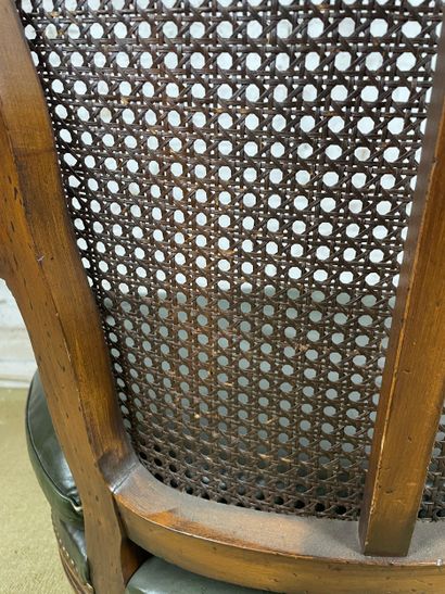 Fauteuil en bois sculpté, cannage et cuir...