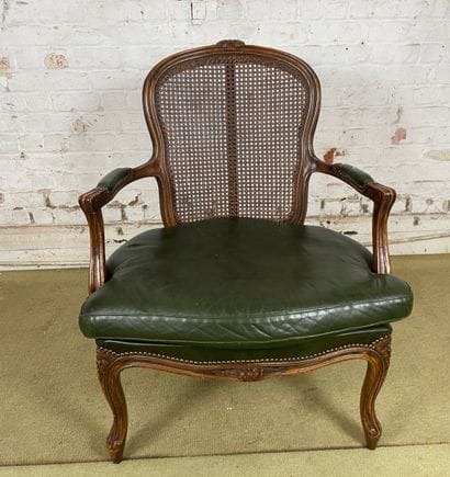 Fauteuil en bois sculpté, cannage et cuir...