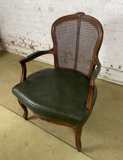 Fauteuil en bois sculpté, cannage et cuir...
