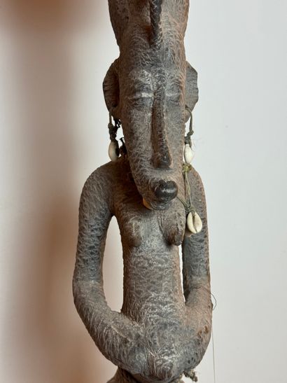 SEATED FEMALE FIGURE WEARING A BOWL ON HER...