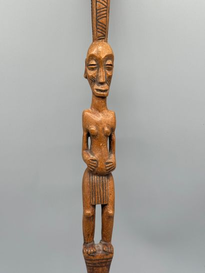 STICK WITH A FEMALE FIGURE 
Light wood. Incised...