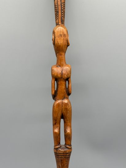 STICK WITH A FEMALE FIGURE 
Light wood. Incised...