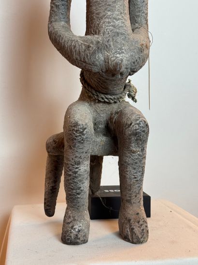 SEATED FEMALE FIGURE WEARING A BOWL ON HER...