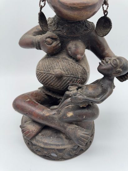 SEATED FEMALE FIGURE HOLDING A STATUETTE
Mid-20th...