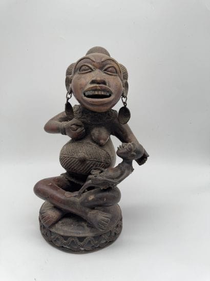 SEATED FEMALE FIGURE HOLDING A STATUETTE
Mid-20th...