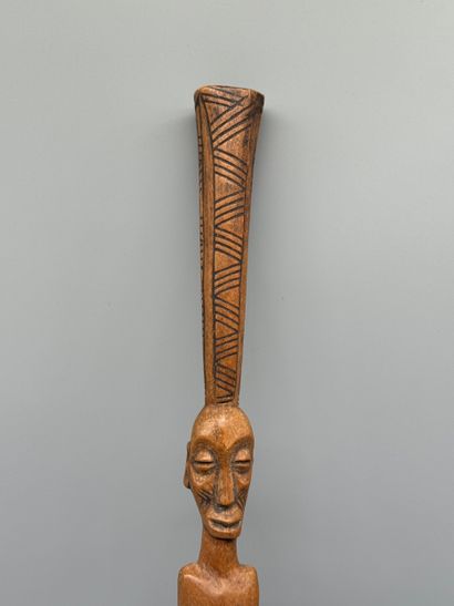 STICK WITH A FEMALE FIGURE 
Light wood. Incised...