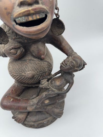 SEATED FEMALE FIGURE HOLDING A STATUETTE
Mid-20th...