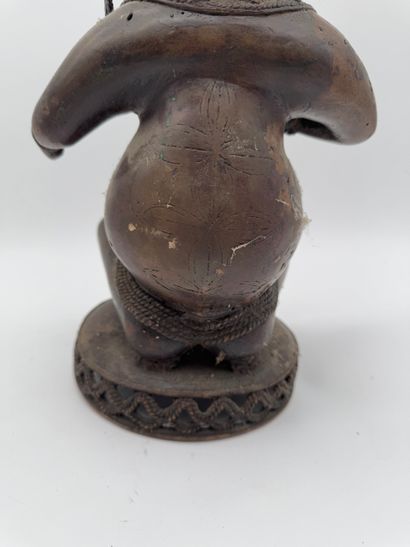 SEATED FEMALE FIGURE HOLDING A STATUETTE
Mid-20th...