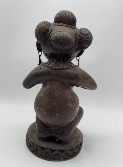 SEATED FEMALE FIGURE HOLDING A STATUETTE
Mid-20th...