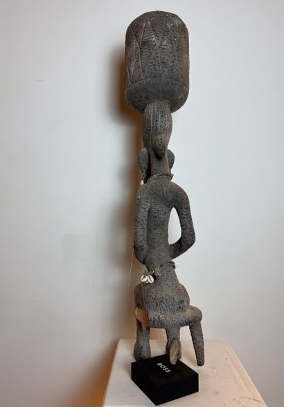 SEATED FEMALE FIGURE WEARING A BOWL ON HER...
