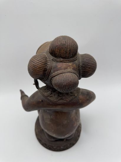SEATED FEMALE FIGURE HOLDING A STATUETTE
Mid-20th...