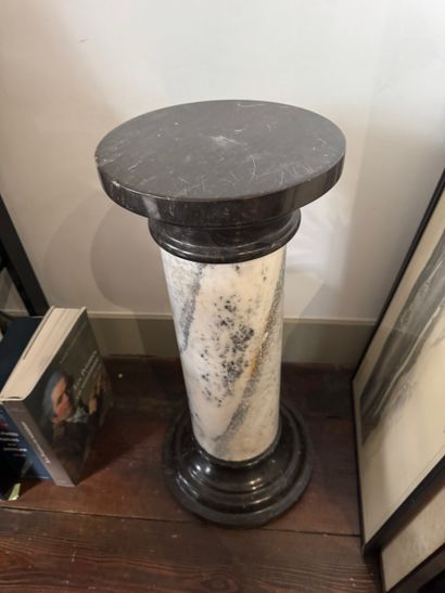 A column-shaped stool made of white marble...