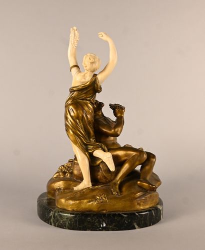 Bronze and ivory group depicting a faun playing...