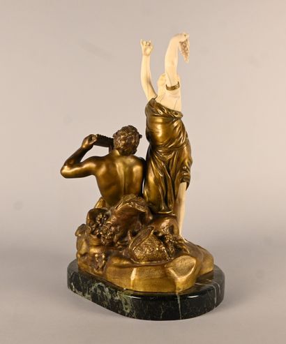Bronze and ivory group depicting a faun playing...