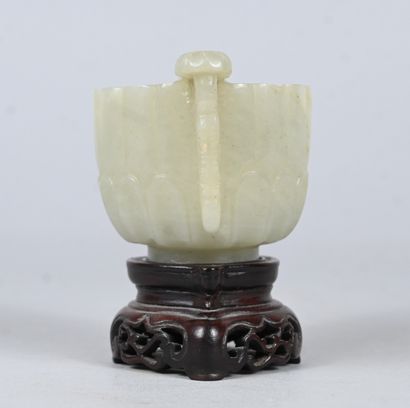 White jade bowl with carved handles on wooden...