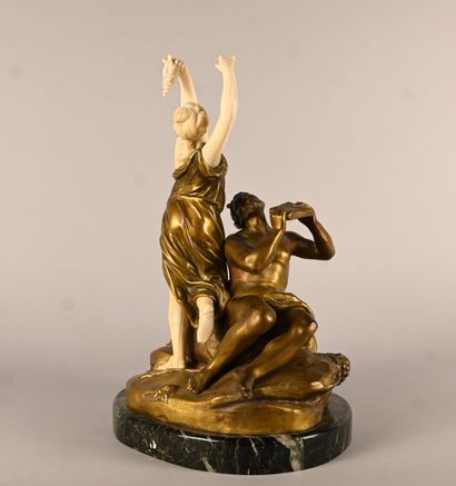 Bronze and ivory group depicting a faun playing...