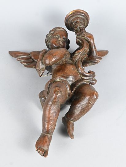 Carved wood wall light featuring a winged...