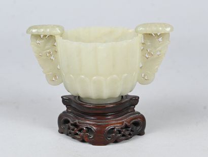 White jade bowl with carved handles on wooden...
