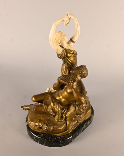 Bronze and ivory group depicting a faun playing...
