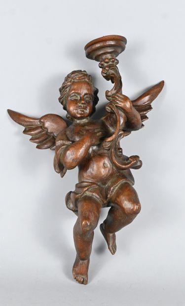 Carved wood wall light featuring a winged...