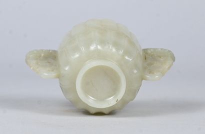 White jade bowl with carved handles on wooden...