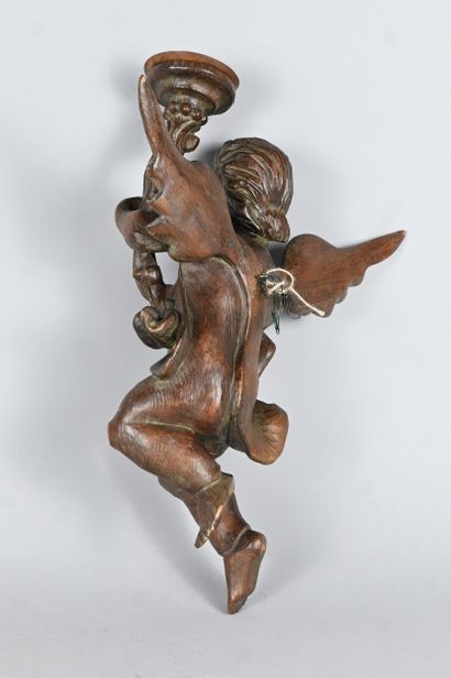 Carved wood wall light featuring a winged...