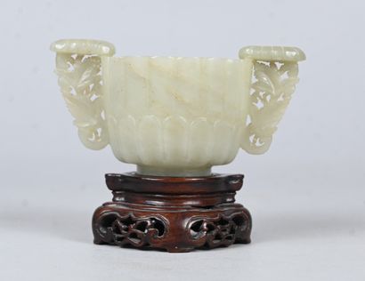 White jade bowl with carved handles on wooden...
