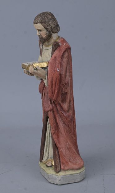 Saint holding a book, religious statue in...