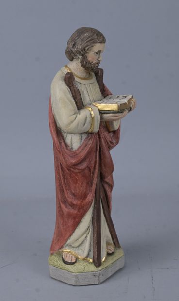 Saint holding a book, religious statue in...