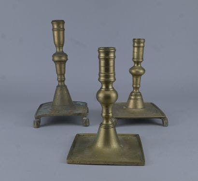 Suite de trois bougeoirs en laiton tourné,...