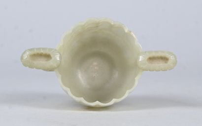 White jade bowl with carved handles on wooden...