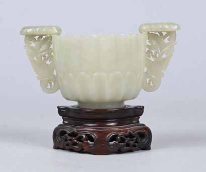 White jade bowl with carved handles on wooden...