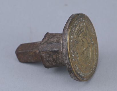 18th-century metal seal with a coat of arms

An...