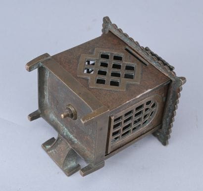 Brass piggy bank in the shape of a cash register,...