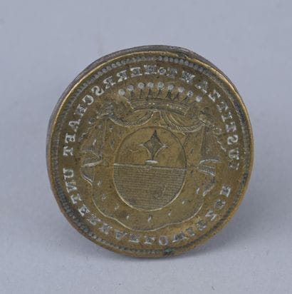 18th-century metal seal with a coat of arms

An...