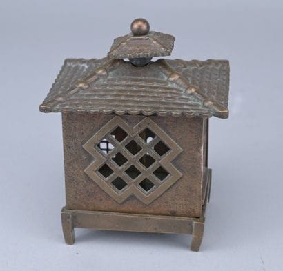 Brass piggy bank in the shape of a cash register,...