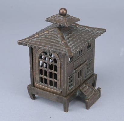 Brass piggy bank in the shape of a cash register,...