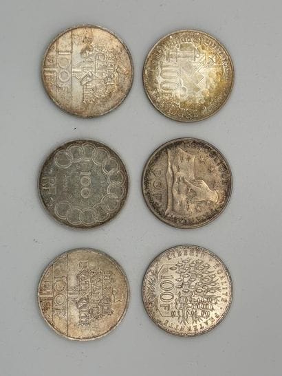 Six 100-franc silver coins.