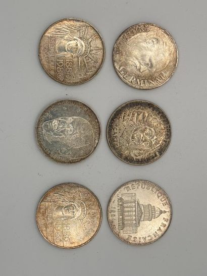 Six 100-franc silver coins.