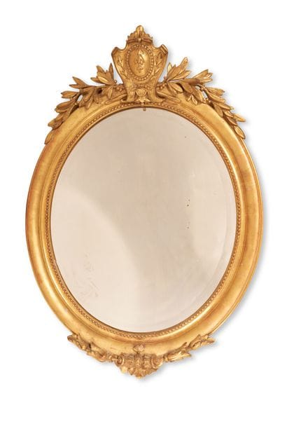 Oval mirror in wood and gilded stucco decorated...