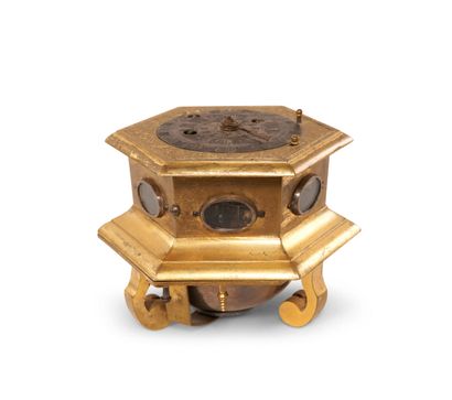 A bronze and engraved brass table clock of...