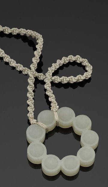 Twisted cord necklace holding a circular...