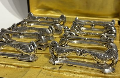TWELVE SILVER-METAL HOLDERS, each formed...