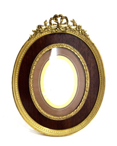 SMALL oval frame in wood and gilded metal,...